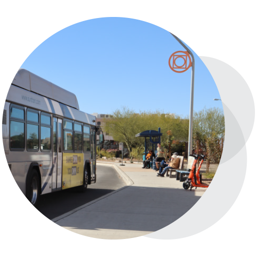A bus approaches a bus stop.